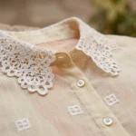 Cream colored women's vintage shirt featuring an intricate floral lace Peter Pan collar and geometric embroidery (3)