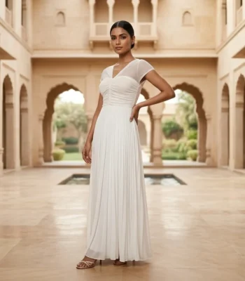 Elegant white floor length pleated gown for women featuring a V neckline, sheer cap sleeves, and a dramatic back bow detail (1)