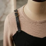 Woman wearing a premium beige and black faux layered knit top with leather strap accents (2)