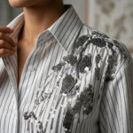 Women's white and black vertical pinstripe long sleeve shirt featuring 3D floral embroidery and dark metallic sequins on the left shoulder (4)