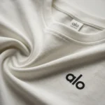 Women's white boxy fit crew neck top featuring extended cap sleeves and a minimalist logo (3)