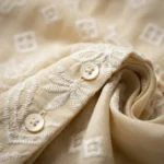 cream colored women's vintage shirt featuring an intricate floral lace Peter Pan collar and geometric embroidery.