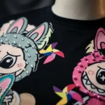 Black oversized t shirt featuring colorful cartoon characters, 3D pink pearls, and rhinestone embellishment (3)