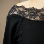 Elegant black long sleeve top for women featuring an asymmetric floral lace neckline and lace trimmed cuffs (4)