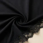 Elegant black long sleeve top for women featuring an asymmetric floral lace neckline and lace trimmed cuffs (5)