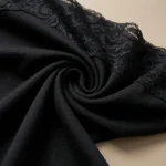 Elegant black long sleeve women's top with asymmetric floral lace neckline detail (5)