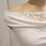 Elegant white off shoulder draped women's top with intricate floral lace back and shoulder detailing (5)