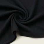 Front and back view of a woman wearing a slim fit black full sleeve top with a draped boat neck (3)