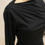 Front and back view of a woman wearing a slim fit black full sleeve top with a draped boat neck (4)