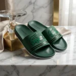 Front view of Lacoste green slides with oversized crocodile logo and white sole (3)