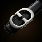 Front view of a men's black leather belt with a polished silver interlocking monogram buckle (2)