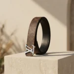 Louis Vuitton women's reversible monogram belt with silver LV initiales buckle on a stone pedestal (1)