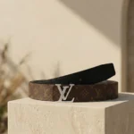 Louis Vuitton women's reversible monogram belt with silver LV initiales buckle on a stone pedestal (3)