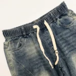 Men's light wash paneled baggy jogger jeans with white drawstring and elastic waistband (1)