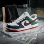 Nike SB Dunk Low sneaker featuring navy blue toe overlays, forest green heel panels, and a red bordered swoosh on a marble surface (1)