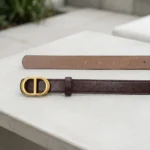 Slim dark brown leather belt for women featuring a matte gold oval CD buckle (1)