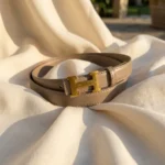 Slim taupe leather women's belt with gold H motif buckle, premium fashion accessory (4)