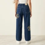 Woman wearing Chanel high waisted wide leg indigo denim jeans with pearl CC logo embellishments (1)