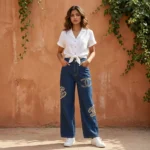 Woman wearing Chanel high waisted wide leg indigo denim jeans with pearl CC logo embellishments (4)