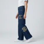 Woman wearing Chanel high waisted wide leg indigo denim jeans with pearl CC logo embellishments (5)