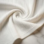 Women's ivory ribbed knit co ord set featuring a V neck sleeveless waistcoat with embossed gold buttons and matching wide leg trousers (3)