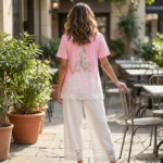 a pink crew neck top with white lace sleeves and V shaped white lace back panel