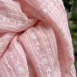 Front and back view of a woman wearing a light pink tiered maxi dress with white floral embroidery (1)