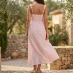 Front and back view of a woman wearing a light pink tiered maxi dress with white floral embroidery (3)