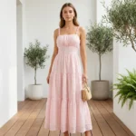 Front and back view of a woman wearing a light pink tiered maxi dress with white floral embroidery (4)