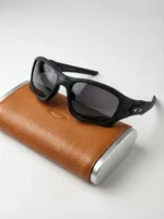 Oakley men's matte black rectangular sports sunglasses with dark grey lenses on a leather case (1)
