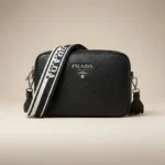 Prada women's black pebbled leather camera bag with wide logo print crossbody strap and silver hardware (4)