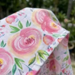 Woman wearing a white midi dress with pink rose print, tie straps, and smocked back (5)