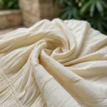 Woman wearing an off white smocked midi dress with pockets (1)