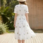 a woman wearing a white tiered midi dress with purple cherry embroidery (3)