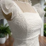 white textured mini dress with sheer yoke and ruffled cap sleeves, featuring a back bow detail (4)