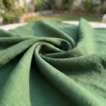 Woman wearing a solid green long sleeve shirt dress with side pockets (3)