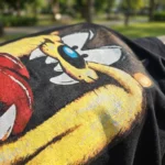 Women wearing a black oversized t shirt with a large yellow graphic print on the front (2)