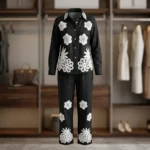 woman wearing a black co ord set with white floral embroidery, highlighting the button down shirt design (2)