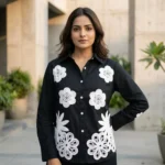 woman wearing a black co ord set with white floral embroidery, highlighting the button down shirt design (5)