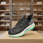 Black athletic running shoe with white midsole and mint green outsole (2)