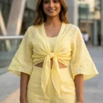 Women wearing a pastel yellow linen tie front short shrug top with wide bell sleeves (3)