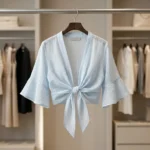 oman wearing a light blue tie front women's short shrug over a top (1)