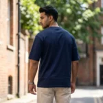 Man wearing a mens navy blue oversized essentials graphic t shirt (1)