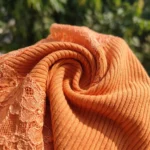 Woman wearing a stylish peach ribbed lace v neck top with rhinestone (1)