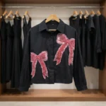 Women wearing a black crop shirt with pink beaded bow design (1)